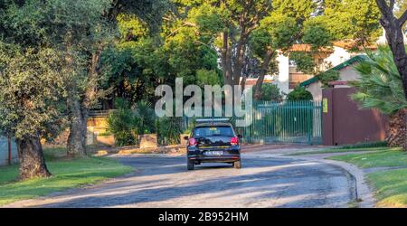 Alberton, Südafrika - ein privates Sicherheitsfahrzeug patrouilliert eine leere Straße im Wohnvorort Brackendowns Bild in horizontalem Format Stockfoto