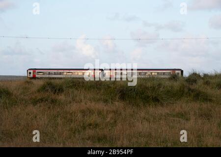 Transport für Wales, Klasse 158, Express Sprinter, Diesel-Mehreinheitenzug, der die Sanddünen nördlich von Tywyn, (Towyn), Gwynedd, Wales durchquert. Stockfoto