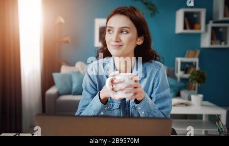 Träumende Frau, die den Becher hält Stockfoto