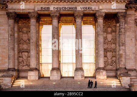 23. März 2020, Berlin: Polizeibeamte bewachen den Eingang zum Reichstaggebäude, dem Sitz des Deutschen Bundestages. Der Bundestag will sich trotz der Koronakrise am Mittwoch zu einer Sitzung treffen. Um die Ausbreitung des Corona-Virus zu verlangsamen, hat die Bundesregierung das öffentliche Leben erheblich eingeschränkt. Foto: Carsten Koall / dpa Stockfoto