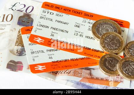 Zwei Zugtickets (Bristol Parkway nach London Paddington), britische Banknoten und Münzen auf weißem Hintergrund Stockfoto