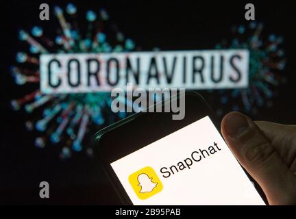 In dieser Abbildung wird das Snapchat-Logo für Multimedia-Messaging auf einem Smartphone mit einem Computermodell des COVID-19-Coronavirus im Hintergrund angezeigt. Stockfoto