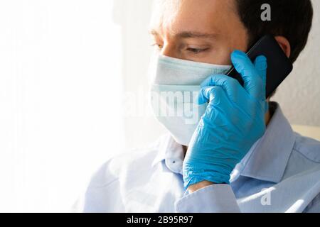 Mann In Maske Und Handschuhe Mit Handy In Coronavirus Quarantäne Stockfoto