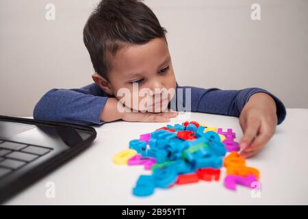 Ein Vorschulter porträtiert Lernstörungen, die das Lernen erschweren und weder an Online-Lehrplänen noch an Manipulativen interessiert sind. Stockfoto