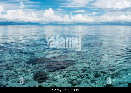 Türkisfarbenes Meerwasser mit blauem Himmel und cumulus-wolken in der Ferne. Stockfoto