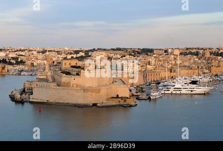 Blick auf den Grand Harbour, Fort St. Angelo und Birgu, Malta von Valletta aus in der Abenddämmerung. Birgu, auch Vittoriosa genannt, ist eine der drei Städte. Stockfoto