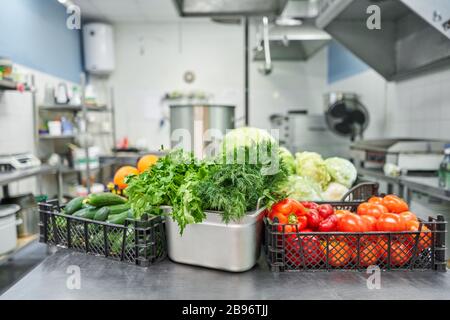 Frisches buntes Gemüse und Obst in der Küche auf silbernem Stahltisch. Arbeitsfläche und Küchenausstattung in der professionellen Küche. Stockfoto
