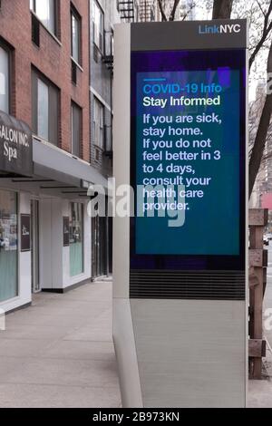 LinkNYC Schild mit digitalem Kiosk auf dem Bürgersteig, auf dem Covid 19 (Coronavirus) Tipps und Ratschläge zur Quarantäne an New Yorker angezeigt werden. Stockfoto