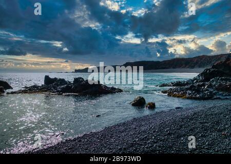 Schwarzer felsiger Strand auf der Halbinsel Snaefellsnes, Island. Dramatisch bewölkter Himmel, keine Menschen sichtbar. Copyspace. Schöne Seescape. Stockfoto