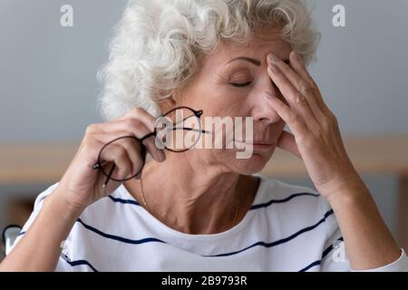 Erschöpfte ältere Frauen leiden unter verschwommener Sicht Stockfoto