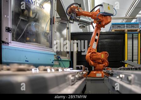 Roboter bei der Arbeit nimmt Aluminiumteil auf Stockfoto