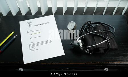 COVID-19 positiver Testergebnisbrief auf dem Schreibtisch Stockfoto