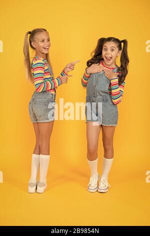 Die besten Freunde. Moderne Mode. Kids Fashion. Kleine Mädchen tragen rainbow Kleidung. Glück. Mädchen lange Haare. Süße Kinder gleichen Outfits zu kommunizieren. Trendy und schick. Emotionale Kinder. Fashion Shop. Stockfoto