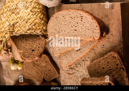 Scheiben von dunklem und weißem Brot im Korb und an Bord Stockfoto