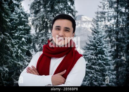 Fröhlicher asiatischer junger Mann mit Winterkleidung Stockfoto