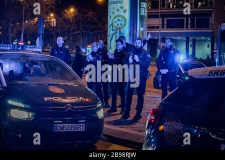 Nationale Polizeibeamte klatschen sich die Hände, um ihren medizinischen Mitarbeitern zu zeigen, die gegen eine Pandemie mit Coronavirus kämpfen. Jeden Tag, um 20 Uhr, versammeln sich mehrere Polizeipatrouillen am Haupteingang des Krankenhauses Fundación Jiménez Díaz in der Innenstadt von Madrid. Polizeibeamte applaudieren, schalten ihre Autoscheinwerfer ein und ertönen ihre Sirenen für einige Minuten, um Ärzten und Krankenschwestern Tribut zu zollen, die gegen Coronavirus kämpfen Stockfoto