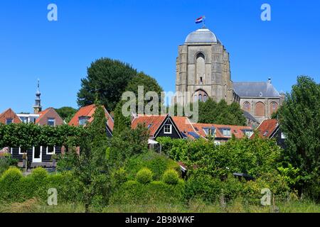 Die niederländische Flagge stolz über die spätgotischen Kirche Unserer Lieben Frau - Grote Kerk (1450-1521) in Veere, Niederlande fliegen Stockfoto