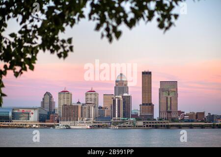 Die Skyline von Louisville bei Sonnenuntergang über dem Ohio River aus Indiana Stockfoto