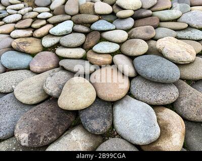 Hintergrund aus mehrfarbigen Steinen unterschiedlicher Form. Stockfoto