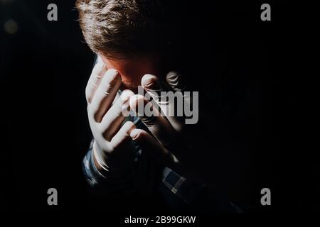 Affraid Mann Hände soziale Distanzierung mit medizinischen Handschuhen und Maske zum Schutz vor Corona-Virus Kovid-19 Stockfoto