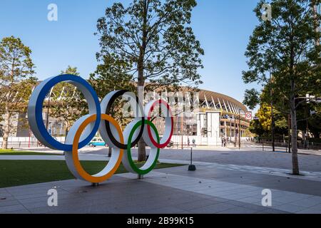 Tokio, Japan - 21.2020: Das Logo der Olympischen Spiele im Tokyo Museum und das neue Nationalstadion im Hintergrund. Stockfoto