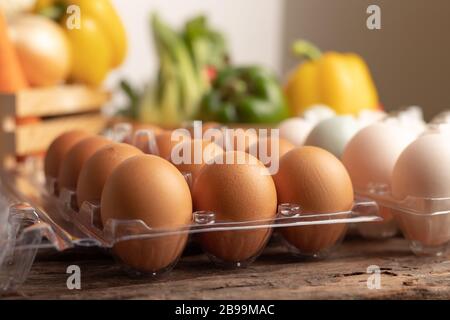 Eier von Huhn und Ente in Kunststoffkiste auf einem Holztisch mit verschiedenen Gemüsesorten auflegen. Wählen Sie Schärfentiefe und unscharfen Bac Stockfoto