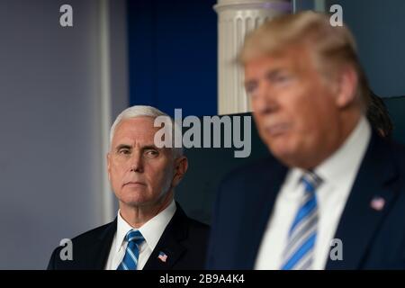 Washington DC, USA. März 2020. Vizepräsident der Vereinigten Staaten Mike Pence hört zu, wie US-Präsident Donald J. Trump während einer Pressekonferenz von Mitgliedern der Coronavirus Task Force im Weißen Haus in Washington, DC am Montag, 23. März 2020 spricht.Credit: Chris Kleponis/Pool über CNP/MediaPunch Credit: MediaPunch Inc/Alamy Live News Stockfoto