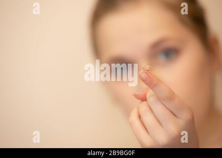 Mädchen hält einen Kontakt auf dem Finger aus Stockfoto