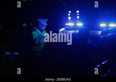 Bukarest, Rumänien. März 2020. Ein rumänischer Polizist kontrolliert Menschen auf den Straßen von Bukarest, Rumänien, 23. März 2020. Rumänien verzeichnete am Sonntag die ersten beiden Todesfälle durch COVID-19, die durch den Roman Coronavirus verursachte Krankheit, da die Gesamtzahl der bestätigten Fälle auf 433 Anstieg. Credit: Cristian Cristel/Xinhua/Alamy Live News Stockfoto