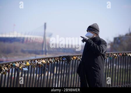 Warschau. März 2020. Ein Mann, der eine Gesichtsmaske trägt, wird mit dem berühmten Nationalstadion im Hintergrund inmitten des COVID-19-Ausbruchs im Zentrum von Warschau, Polen am 23. März 2020 gesehen. Kredit: Jaap Arriens/Xinhua/Alamy Live News Stockfoto