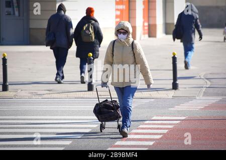 Warschau. März 2020. Eine Frau, die eine Gesichtsmaske trägt, überquert eine Straße inmitten des COVID-19-Ausbruchs im Zentrum von Warschau, Polen am 23. März 2020. Kredit: Jaap Arriens/Xinhua/Alamy Live News Stockfoto