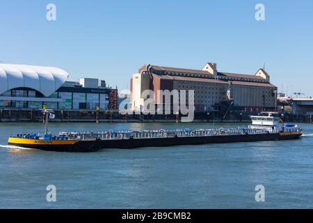 Mannheim, Deutschland; März/23/2020; Lastkähne, die Güter in loser Schüttung entlang des Rheins zum Pass durch die Mannheimer Stadt transportieren. Stockfoto