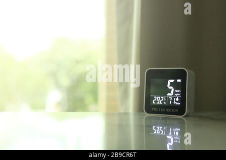 Luftqualitätssensor auf einem Tisch in der Halle. Der Sensor hat eine geringe Luftverschmutzung von PM 2.5 festgestellt, die giftige schädliche Partikel sind nicht sichtbar Stockfoto