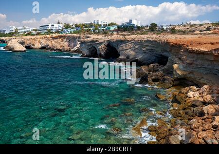Der Blick auf das erhöhte Küstenplateau von Kap Greco mit der Stadt Ayia Napa im Hintergrund. Zypern Stockfoto