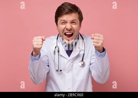 Asiatische chinesische männlichen frustriert verrückte Arzt schreiend in isolierten weißen Hintergrund Stockfoto