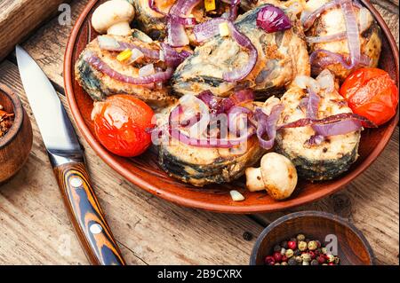 Gebratener Fisch mit gegrilltem Gemüse auf Holztisch.Roastfisch Stockfoto