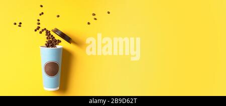 Kaffee- oder Teepapierbecher, Kaffeebohnen auf gelbem Hintergrund. Draufsicht, flaches Layout, Kopierbereich. Nehmen Sie Kaffeetasse und Mockup weg. Minimale Zusammensetzung, Layout Stockfoto