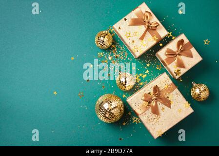 Geschenkbox, glänzende goldene Disco-Bälle, funkelnder Goldglitter auf grünem Hintergrund. Neujahrssitzel, Sternenglitzern. Neujahr, Weihnachten, Valentinstag Co Stockfoto
