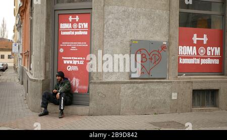Zigeuner sitzen vor der Tür des Fitness-Ghettos der Gemeinde in Brünn, Bratislava, Straßenleben Menschen mit Frauen und Männern mit Zigeunerhof Stockfoto