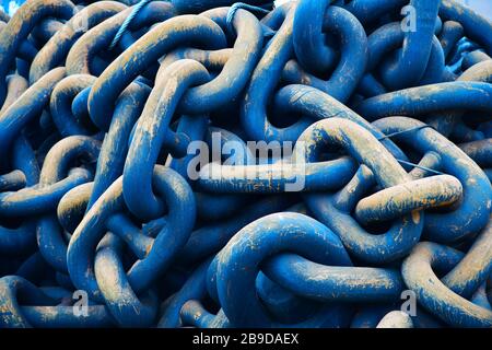 Im Hafen von Rotterdam türmen sich riesige schwere blaue Ankerketten auf, die zu wettern beginnen und kratzen Stockfoto