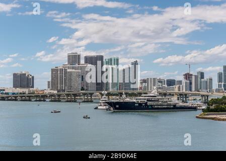 Miami, FL, Vereinigte Staaten - 20 April, 2019: Miami Skyline von Dodge Island an der Biscayne Bay gesehen. Lange Verkehr Brücke und Luxus Yacht in der Fo Stockfoto