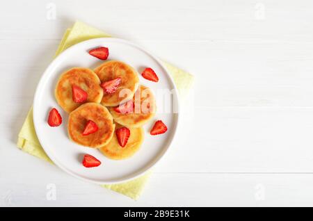 Käsekuchen mit Erdbeere, syrniki auf weißem Hintergrund. Draufsicht, flacher Lay Stockfoto