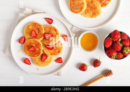 Quark Pfannkuchen mit Erdbeeren Schichten und Honig. Gesundes Frühstück. Ansicht von oben, flach Stockfoto
