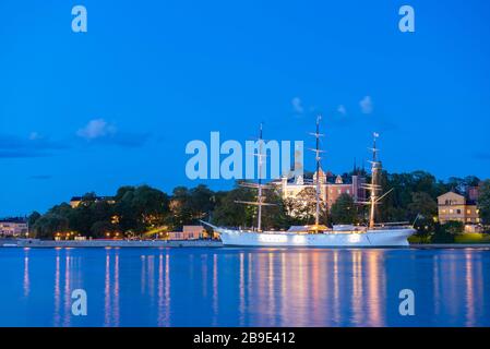 Schöne Nachtansicht auf weißem Segelschiff auf Skeppsholmen Insel in Stockholm, Schweden. Abenddämmerung an der Ostsee. Stockfoto