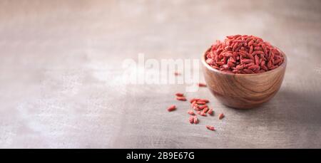 Goji-Beeren in Holzschale auf strukturiertem Holzhintergrund. Kopierbereich. Superfood, veganes, vegetarisches Speisekonzept. Makro der Goji-Beeren, selektiver Fokus Stockfoto