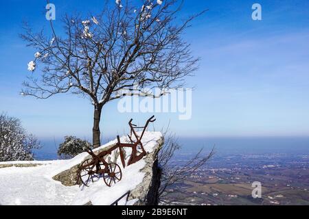 Altmodischer Pflug im Schnee. Alte antike Eselei auf einem Feld Stockfoto