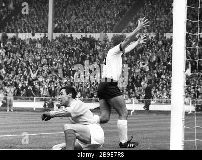 Englands WM-Torhüter von 1966 Gordon Banks verstorben 12.02.2019. Fußball-Weltmeisterei 1966 in England. Finale: England - Deutschland (4:2) 30.07.1966 im Londoner Wembley-Stadion. Torwart Gordon Banks (engl.) nach dem 1:0 für Deutschland durch Wolfgang Weber (nicht auf der Bild). Lothar Emmerich träumt jubelnd ab. *** England WM-Torhüter 1966 Gordon Banks verstorben 12. 02 2019 Fußball-Weltmeisterschaft 1966 im England Finale England Deutschland 4 2 30 07 1966 im Londoner Wembley-Stadion Torhüter Gordon Banks Engll nach dem 1:0 für Deutschland von Wolfgang Weber nicht auf dem Bild, das Lothar Emmerich dreht Stockfoto