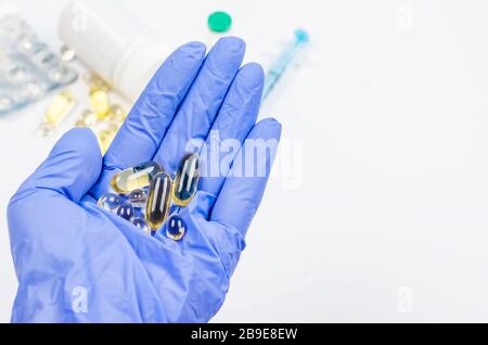 Hand in Handschuhe mit vielen Pillen Pharmazeutische Medizin Konzept, kopieren Raum Mockup, flach lag. Apothekenthema, Behandlungsmedikation. Stockfoto