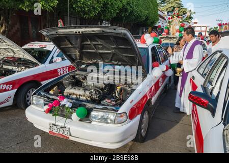 Priest Seeging schmückte vor der Prozession Taxis und Fahrer, Festival of Our Lady of Guadalupe, Straße in Catemaco, Veracruz State, Mexiko Stockfoto