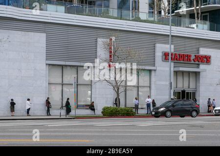 Die Menschen stehen in der Reihe, die soziale Distanzierung üben und warten, bis sie in den Trader Joes, der sich auf 8500 Burton Way befindet, nach der Coronavirus COVID-19-Pandemie, Montag, 23. März 2020, in Los Angeles, Kalifornien, USA (Foto von IOS/Espa-Images) eindringen. Stockfoto